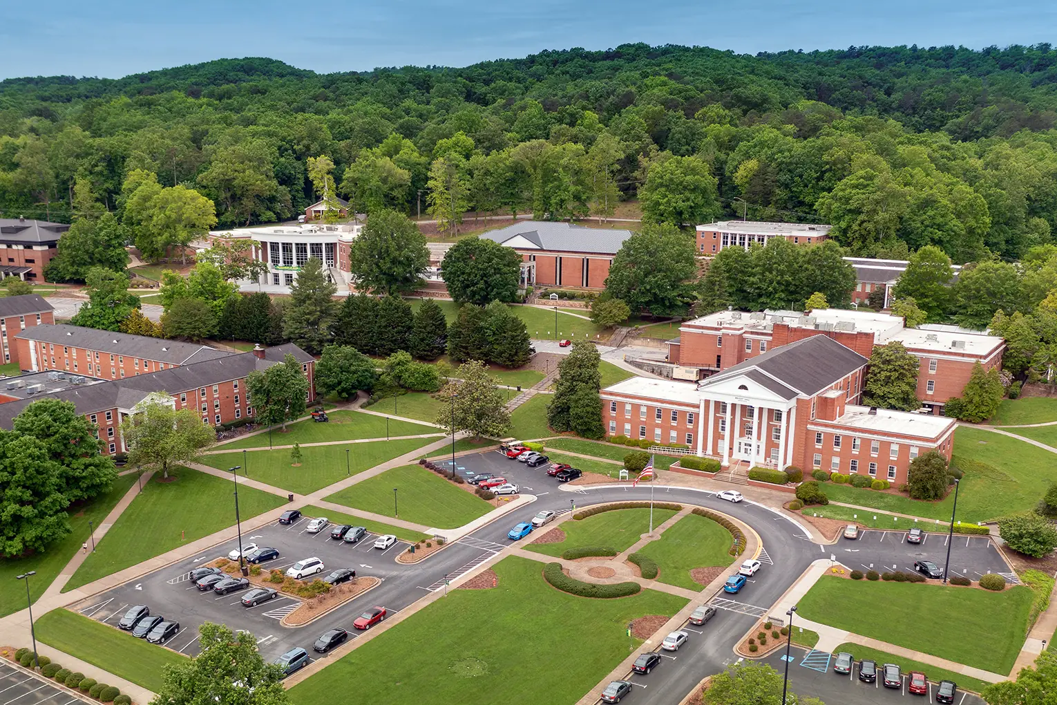 Aerial view of Collegedale, TN, with the Southern Adventist University campus and a wooded ridge behind it