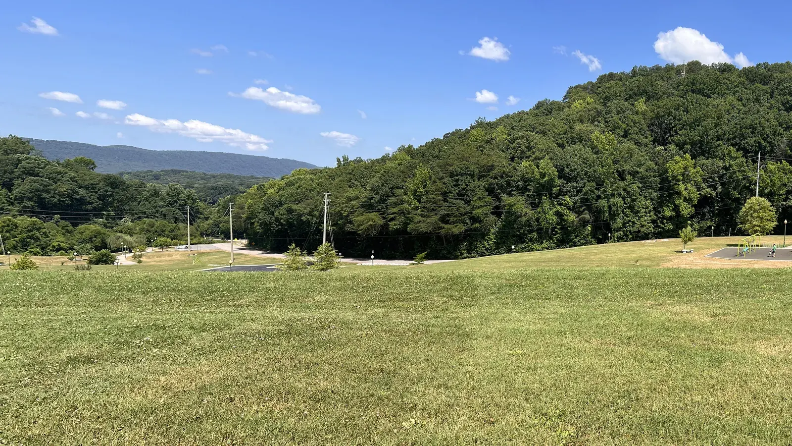 View north from White Oak Park in Red Bank, TN, with a wooded hillside and a long ridge on the horizon